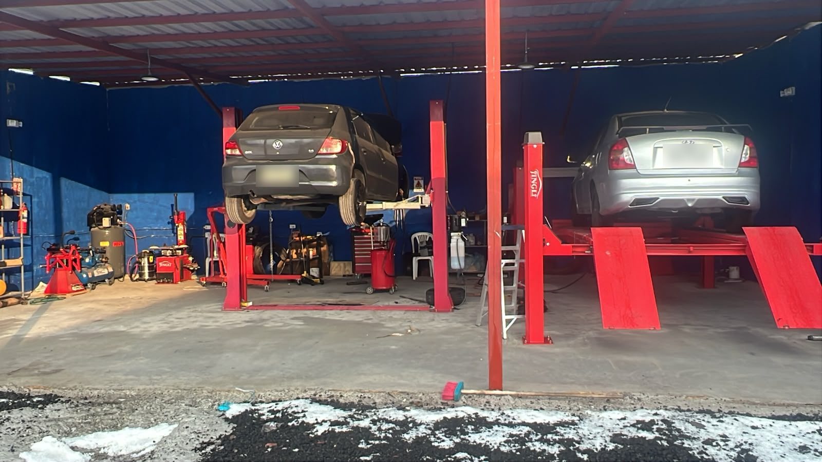 Nave del tecnicentro AQY Motors con dos vehículos en los elevadores